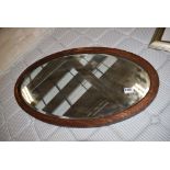 Oval bevelled mirror in oak frame