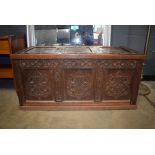6 (rr aug) 20th century oak and panelled coffer decorated with carved foliate carvings throughout,