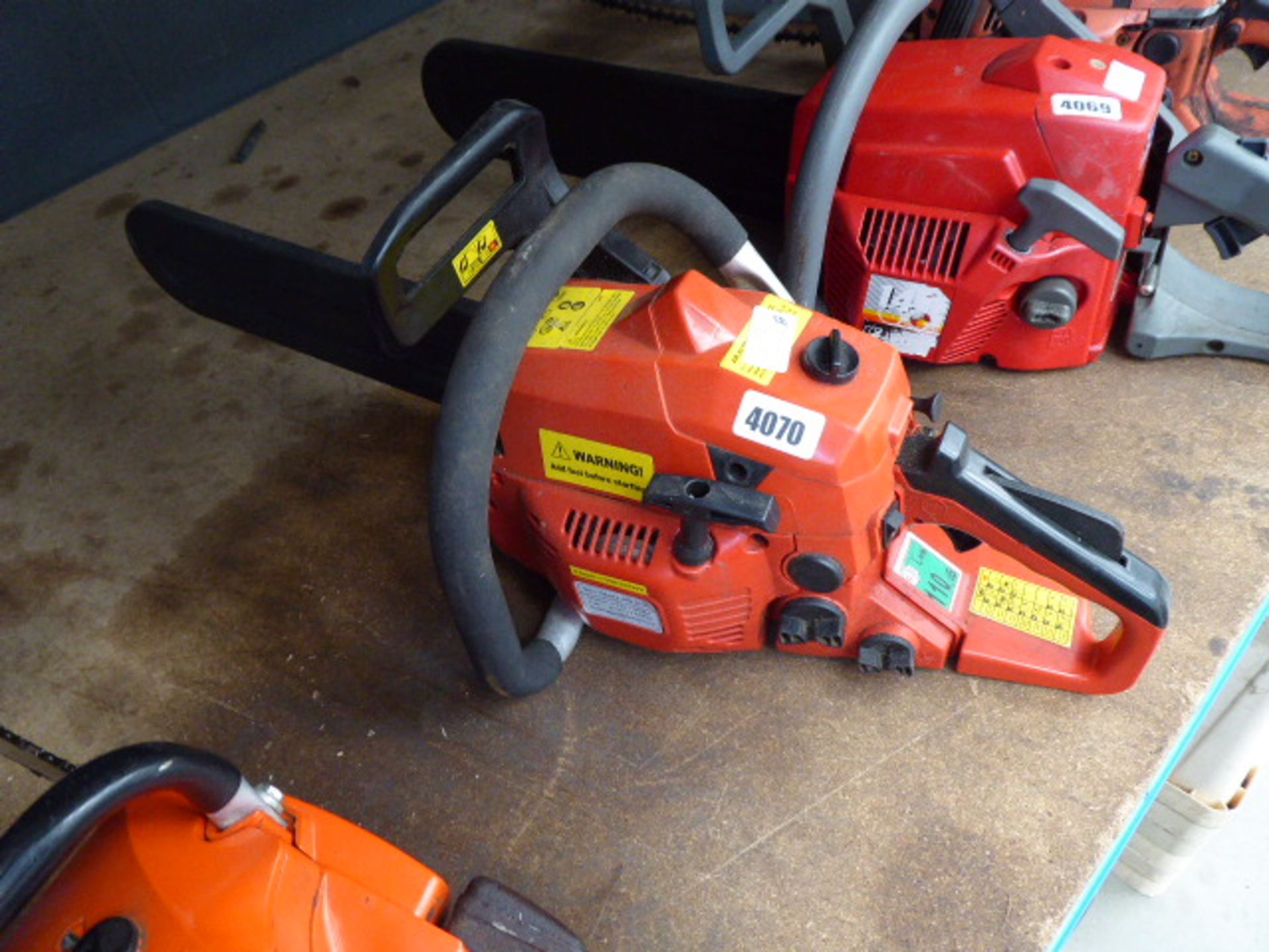 Red petrol powered chainsaw