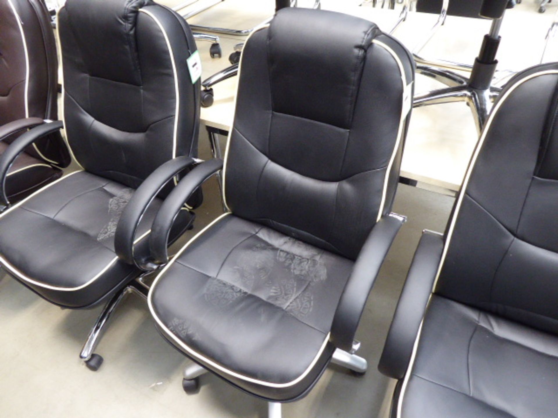 Black high-back executive swivel armchair with cream piping