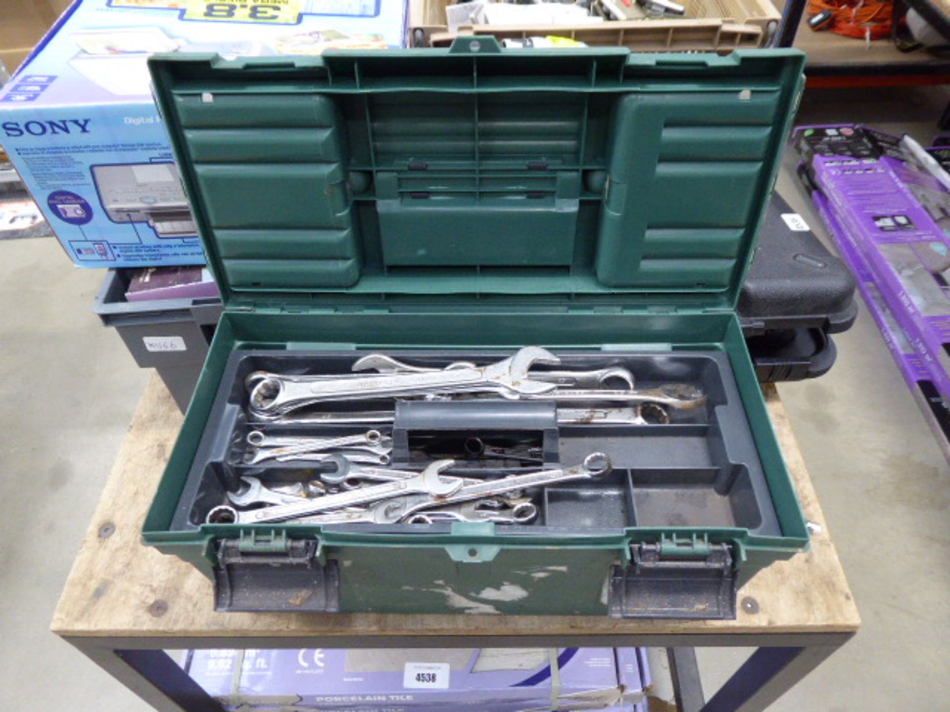 Green plastic toolbox with quantity of assorted spanners