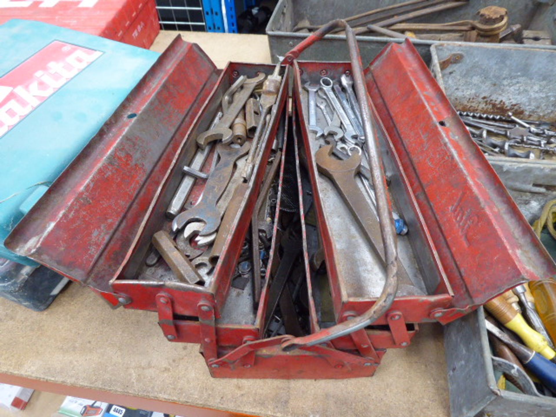 red metal toolbox containing quantity of spanners