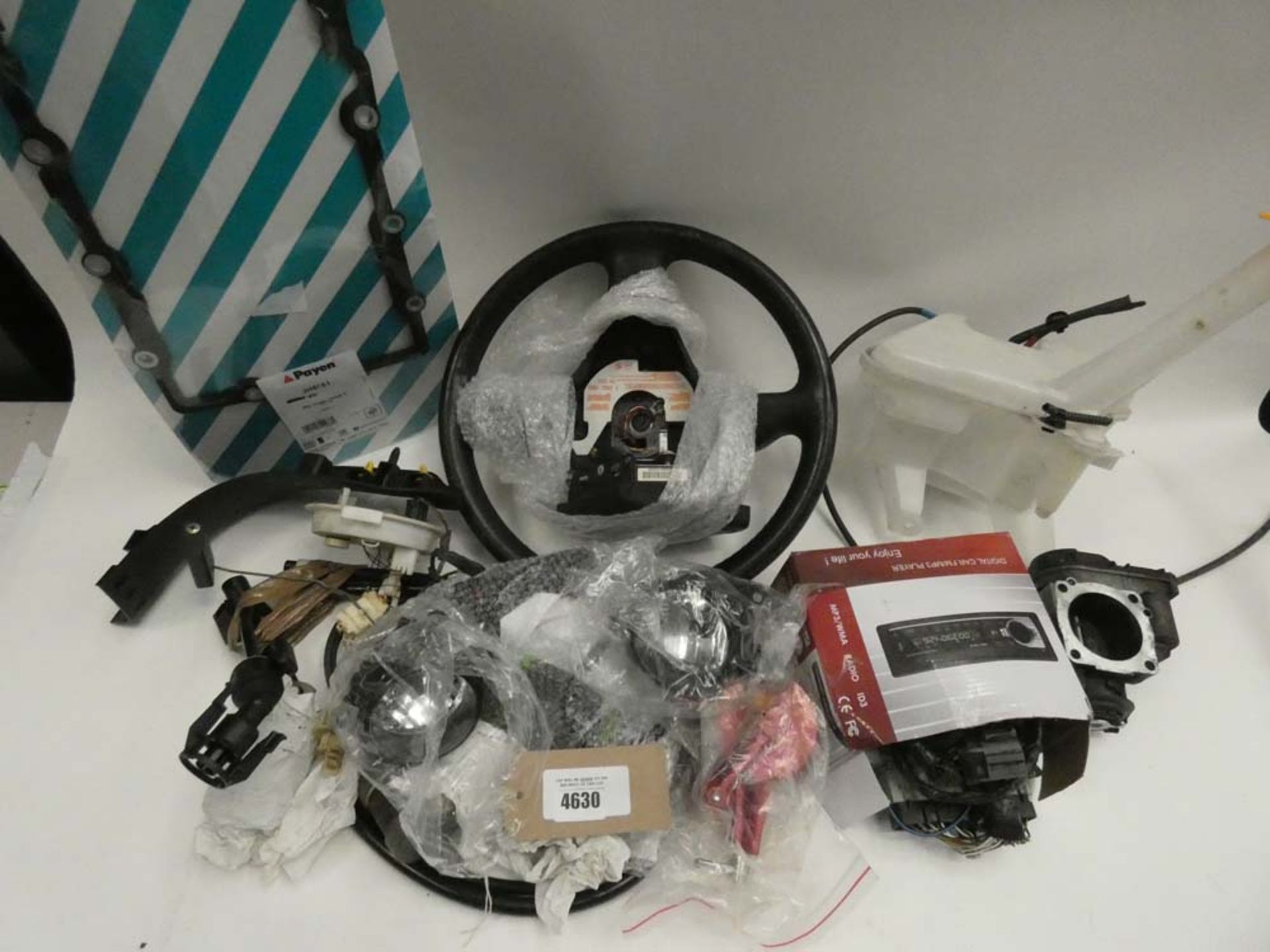 Bag of car parts including steering wheels, washer bottles, gaskets, lights, and other parts