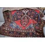 Persian woollen rug with red ground and floral decoration