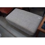 A grey fabric footstool