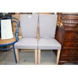 A pair of grey fabric dining chairs