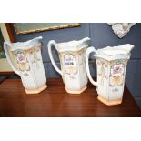 Three graduated floral decorated jugs