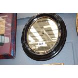 Oval mirror in dark wood frame