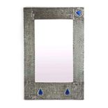 An Arts & Crafts mirror, the hammered pewter frame with enamelled roundels,
