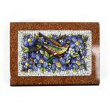 A micromosaic depicting a singing bird amidst bright foliage, on a marble and glass mounted base,