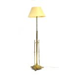 A brass standard lamp in the Arts & Crafts manner