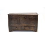 An 18th century oak panelled mule chest, the lift lid over three panels and two drawers,