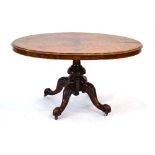 A Victorian walnut loo table, the oval tilt-top on a column base and four splayed legs with castors,