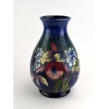 A large Moorcroft vase of ovoid form decorated with iris and other flowers on a shaded blue/green
