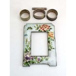 A cloisonne enamelled photograph frame of rectangular form decorated with blossoming shrubs and