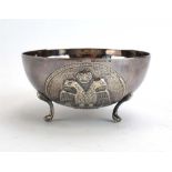 A Cypriot metalware sugar bowl repousse decorated with a double eagle on three paw feet,