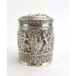 A Burmese metalware box and cover of cylindrical form, repousse decorated with dancing figures, h.