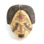 A South African mask with central parting, brown pigment and pursed lips, h.