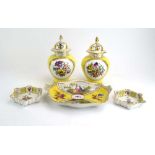 A pair of jars and covers of baluster form, decorated with floral sprays within yellow grounds,