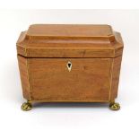 A Regency walnut, strung and crossbanded tea caddy with a rosewood interior, on gilt claw feet, w.