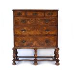 A walnut and crossbanded chest-on-stand with an arrangement of three short over three long