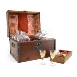 An oak and metal bound case containing a travelling set of etched glass and gilt decanters and