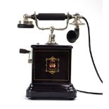 A 1920's Danish hand-cranked telephone with a black lacquered case,