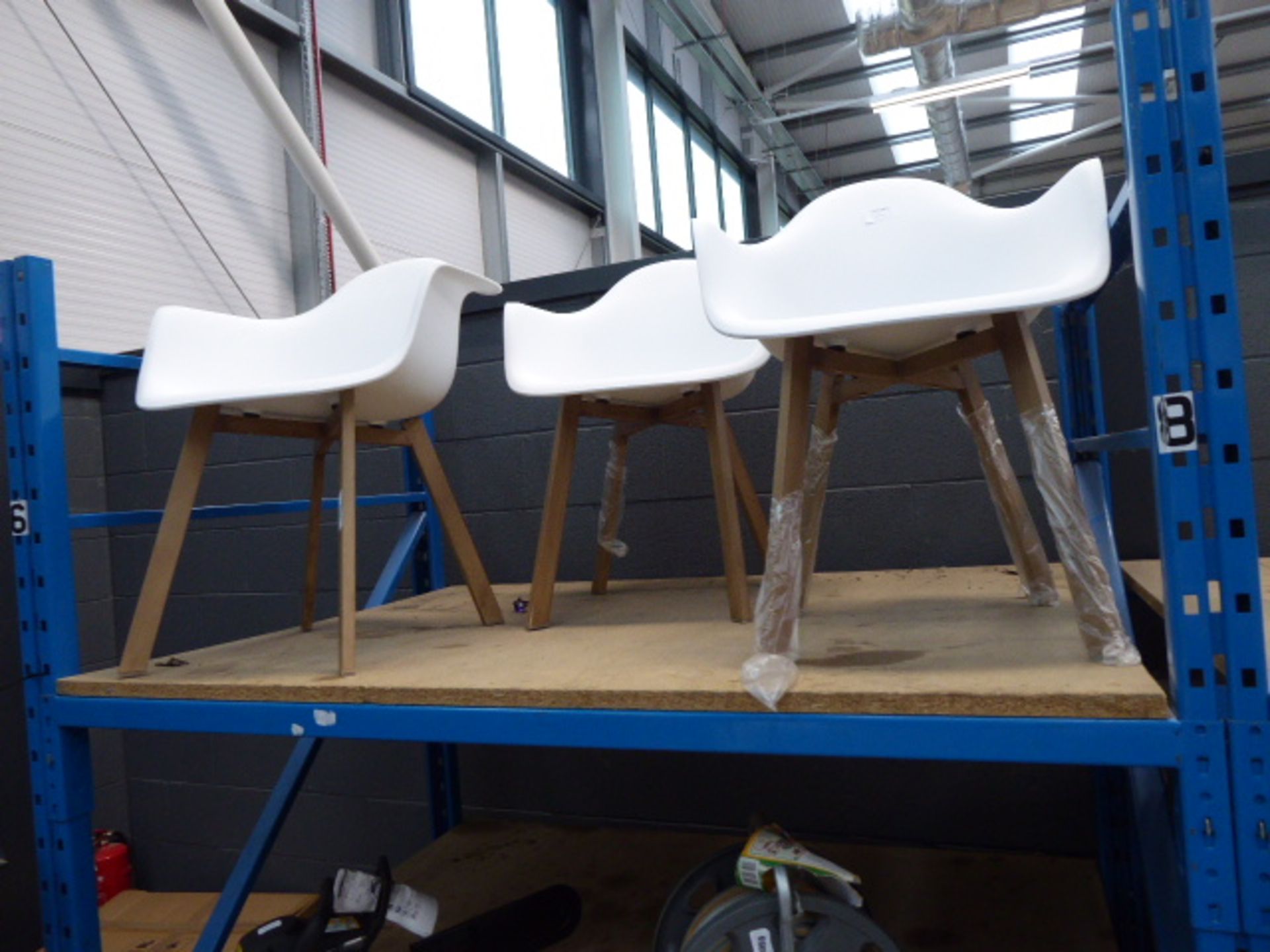 3 white plastic tub style chairs with wooden legs