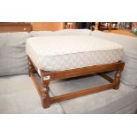 Wooden framed footstool with leaf patterned cushion