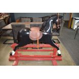 Black rocking horse on red stand