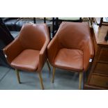 Two tan brown leather effect tub chairs