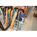 Collection of fold away chairs together with an easel, walking sticks and umbrella