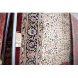 (16) Beige brown floral pattern rug edged in dark red