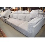 Large grey fabric covered L shaped sofa and footstool
