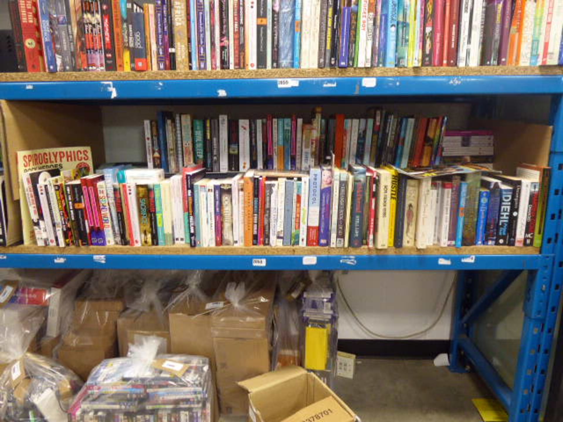 Shelf comprising of a large selection of paperback and hardback novels, autobiographies, self help