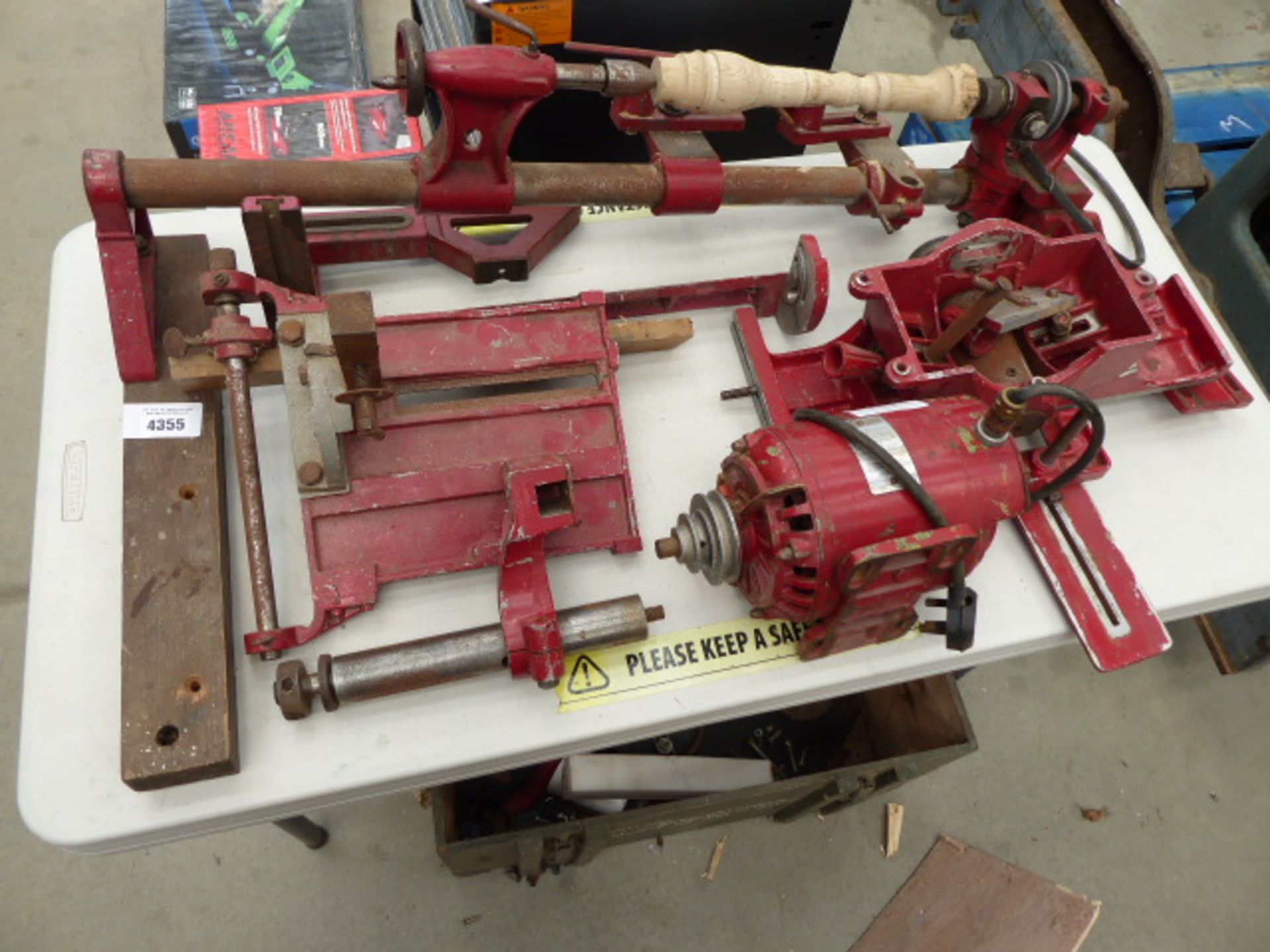 Table top containing a lathe, motor and lathe parts including a green army style box