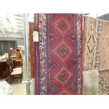 Afghan carpet runner with floral and geometric pattern and a red background