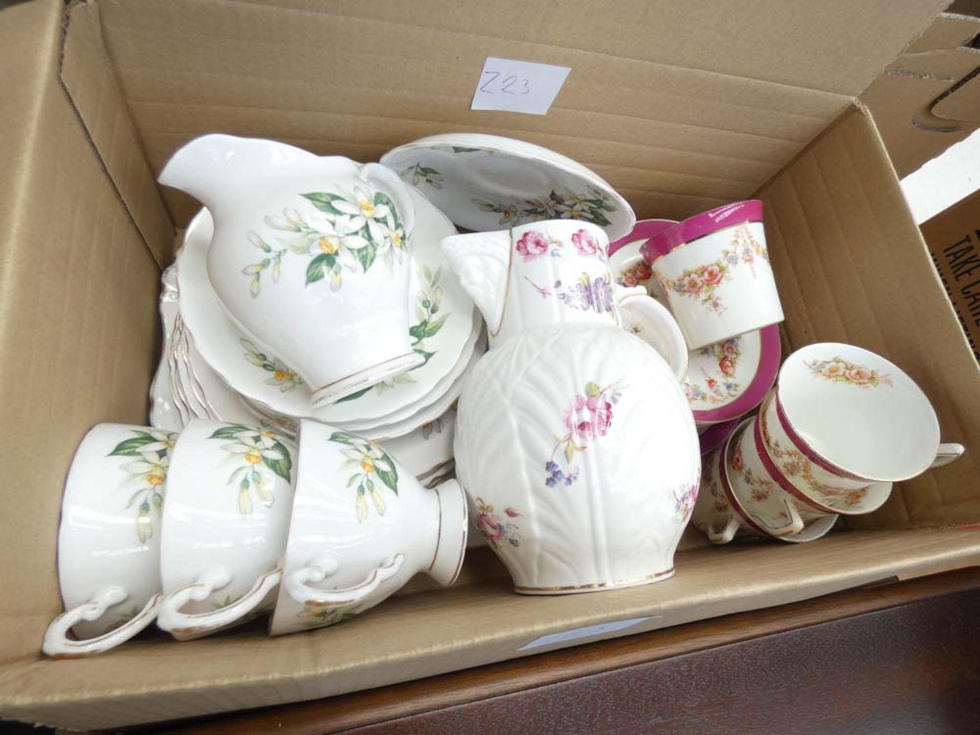 Box containing tusk and floral patterned china