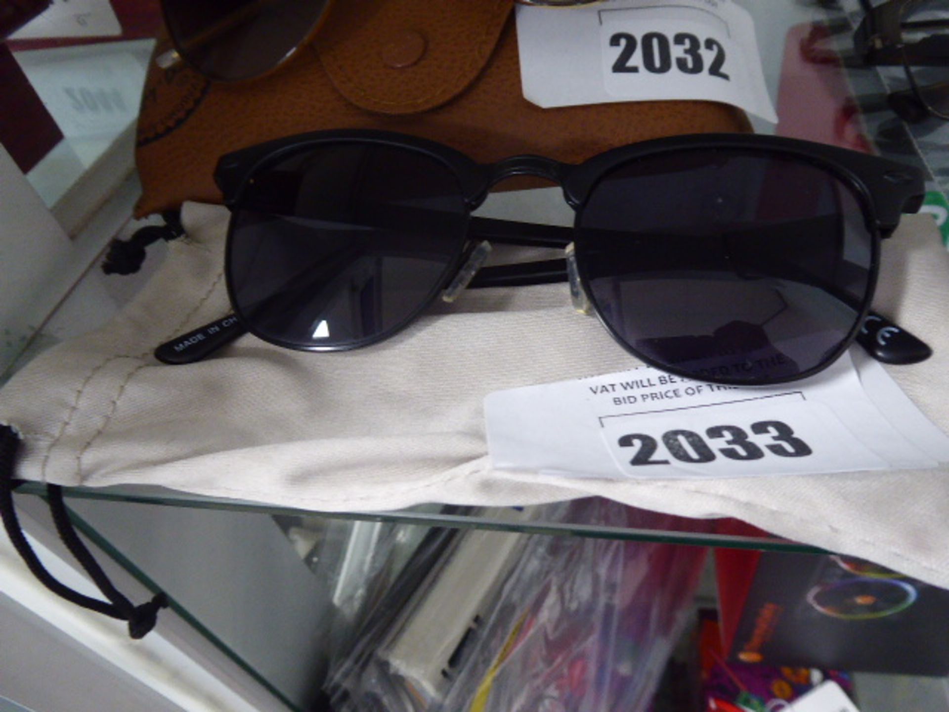 Pair of sunglasses with black frames and soft carry case