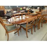 An extending reproduction mahogany dining table plus eight chairs, to include two carvers