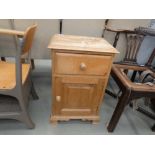 A pine single door pot cupboard with drawer over