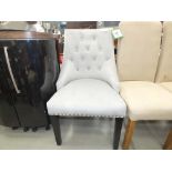 A grey fabric button back dining chair