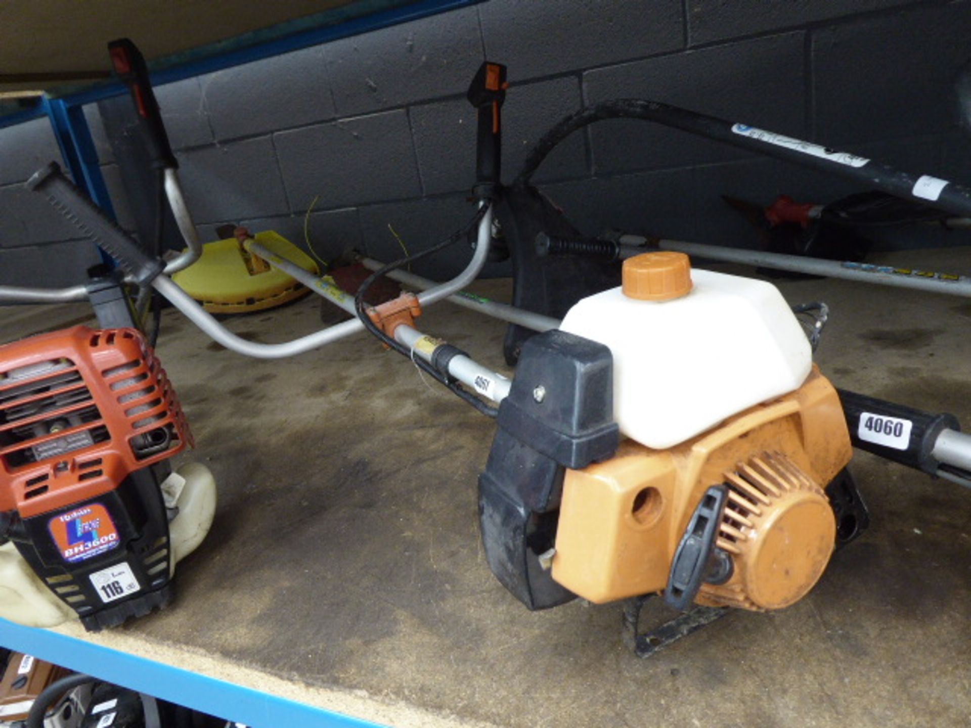 Orange petrol-powered brushcutter