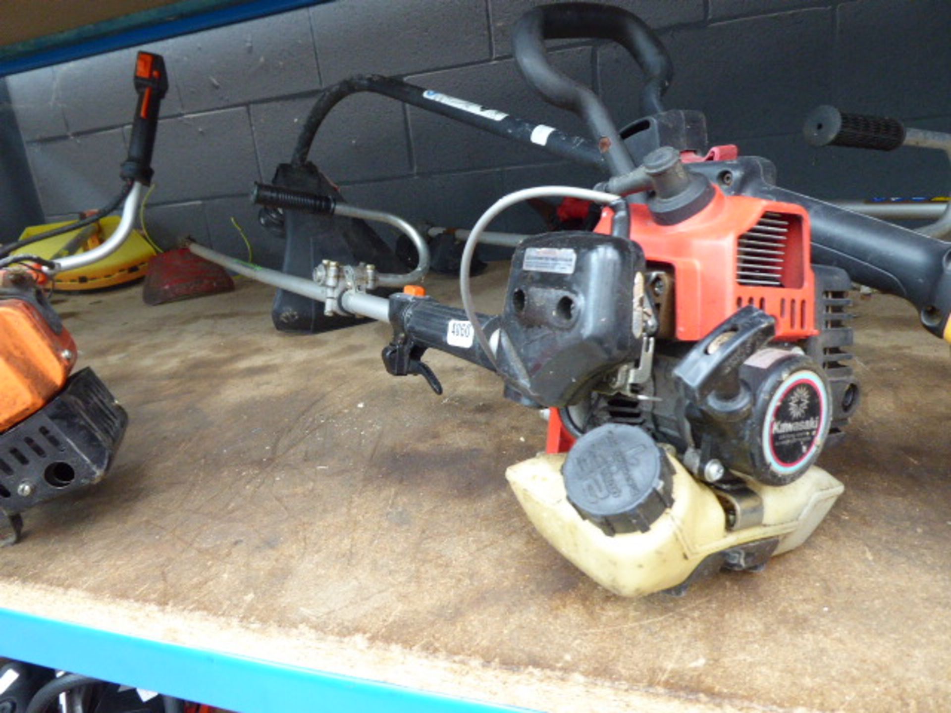 Kawasaki red petrol-powered strimmer