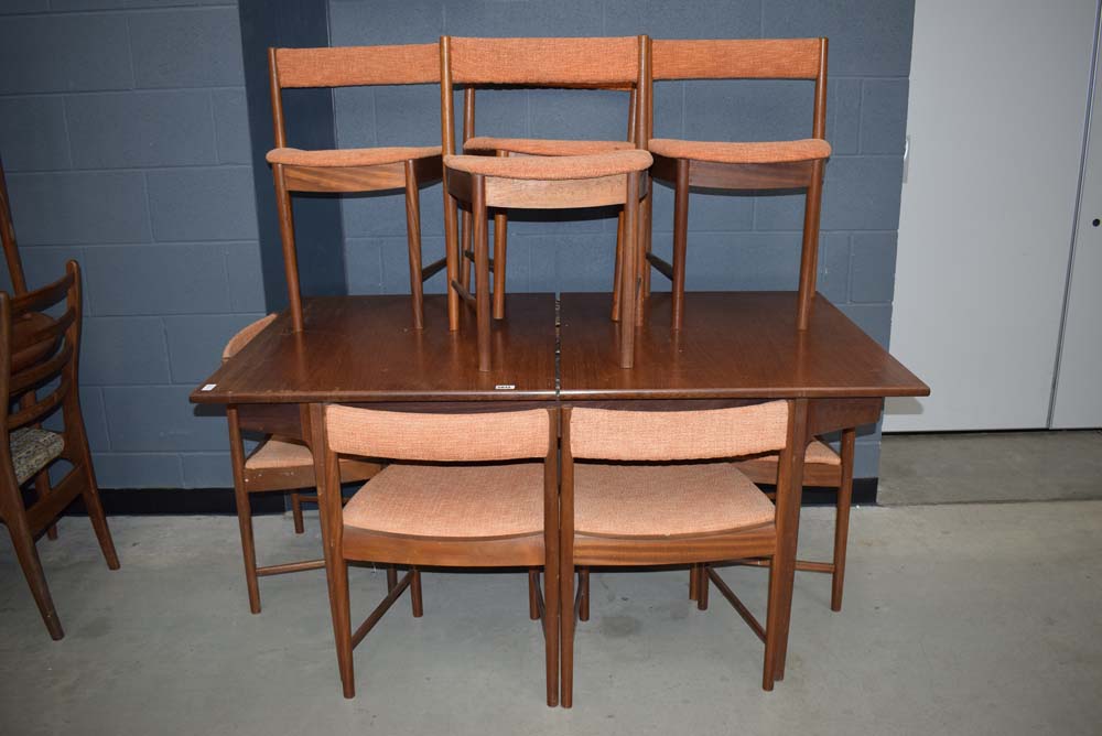 Teak extending dining table with 7 Scandart-designed teak framed chairs with burnt orange upholstery