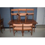 Teak extending dining table with 7 Scandart-designed teak framed chairs with burnt orange upholstery
