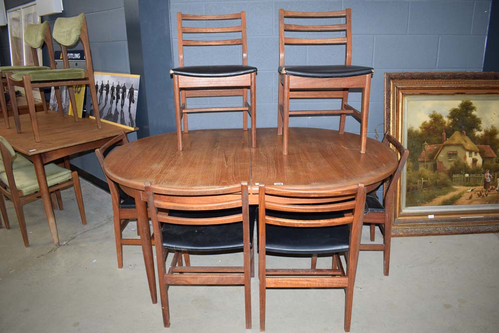 Oval teak extending table with 6 teak framed chairs with black rexine seating, probably G-Plan *