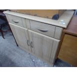 Light oak effect 2 door cupboard with single drawer over