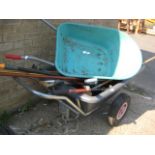 Plastic wheelbarrow containing tools and other wheelbarrow