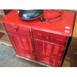 Red painted cabinet with drawers over cupboard